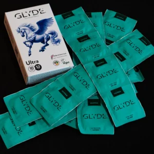 אריזת קונדומים טבעוניים GLYDE Ultra (אולטרה) ברוחב נומינלי 53 מ״מ עם איור פגסוס טורקיז מכונף לצד עטיפות אישיות בצבע טורקיז